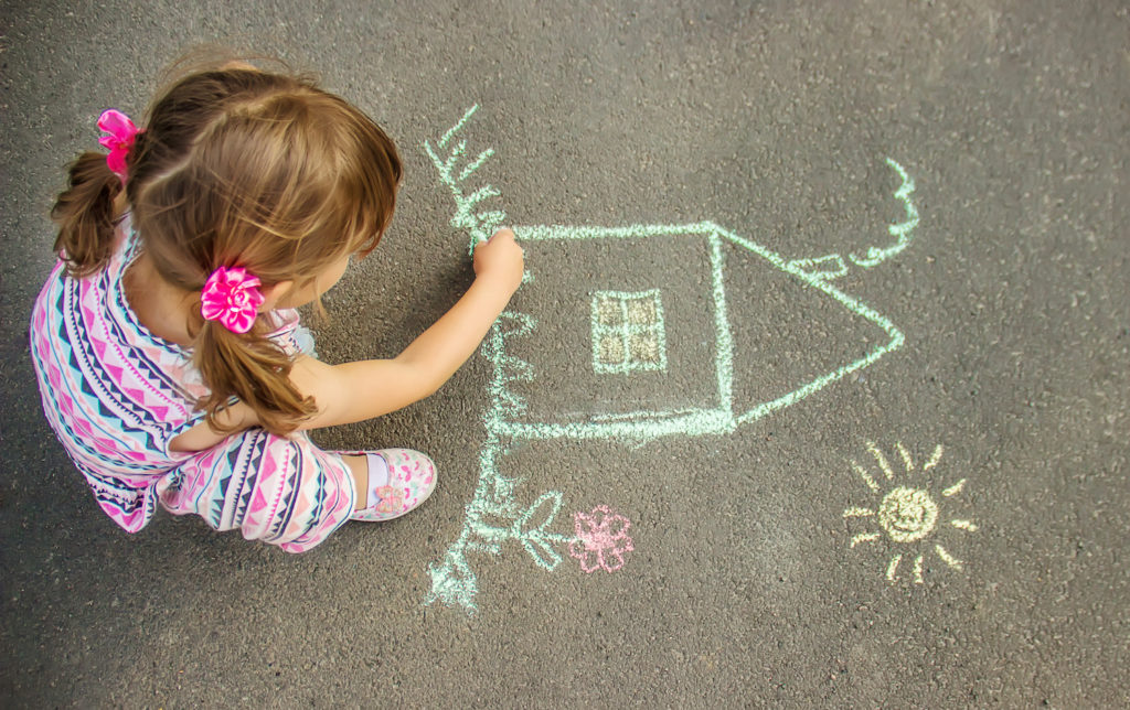 young girl making a doodle art on street floor