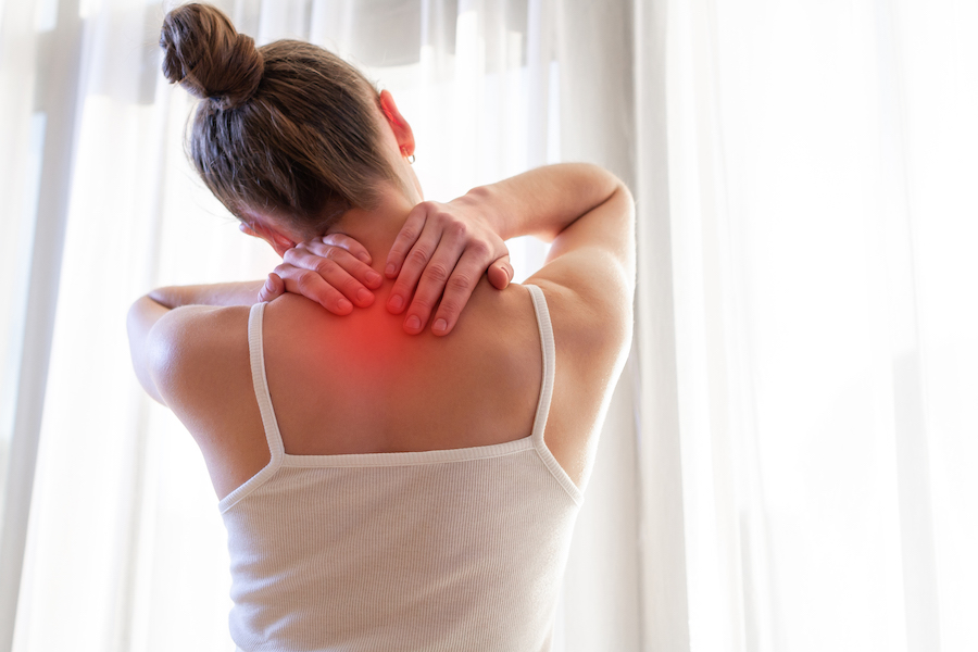 woman holding her lower neck due to pain