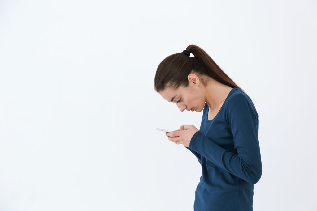 woman looking at her phone, poor posture